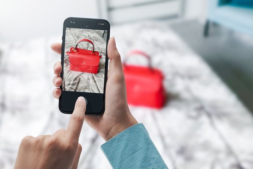 Woman taking a picture of her bag using her smartphone