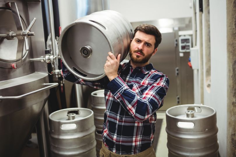 Man carries keg in a bar