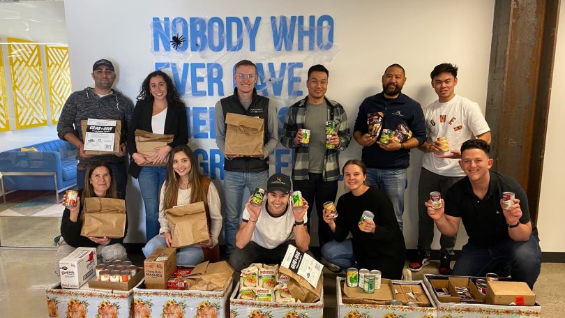 A group photo of the PureSpectrum team at a food bank. 