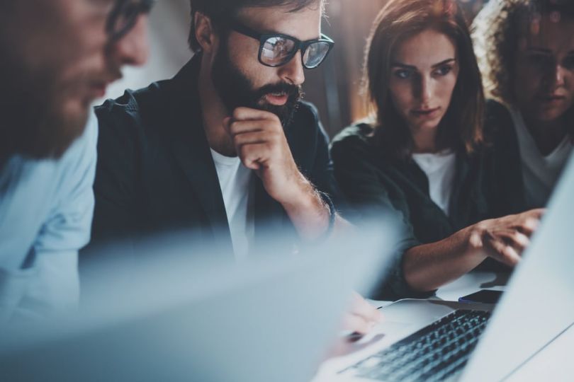 IT team members working together on laptops in office