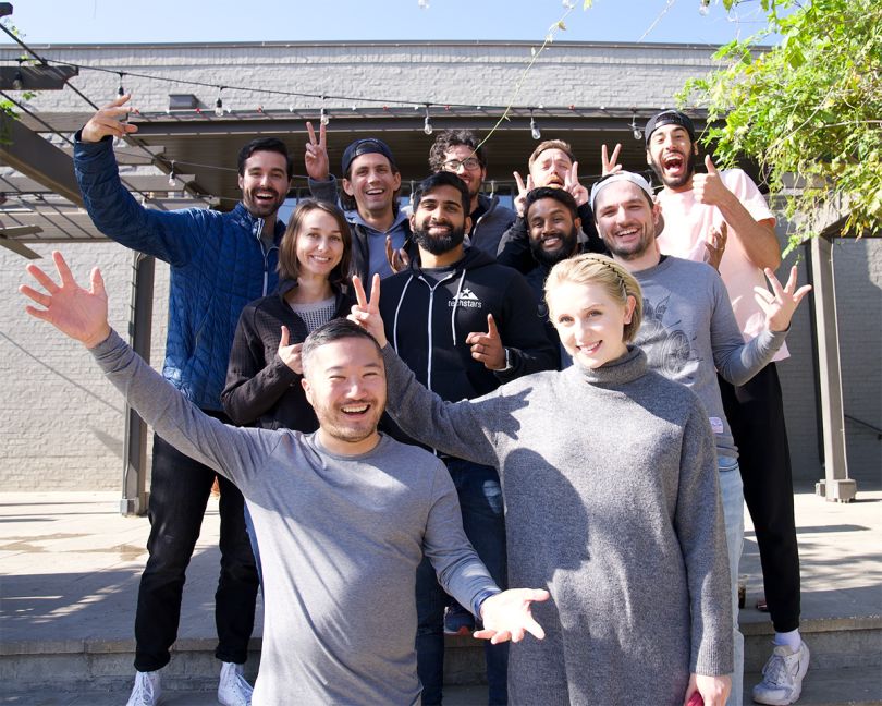 Immersed team members outside giving peace signs and thumbs up