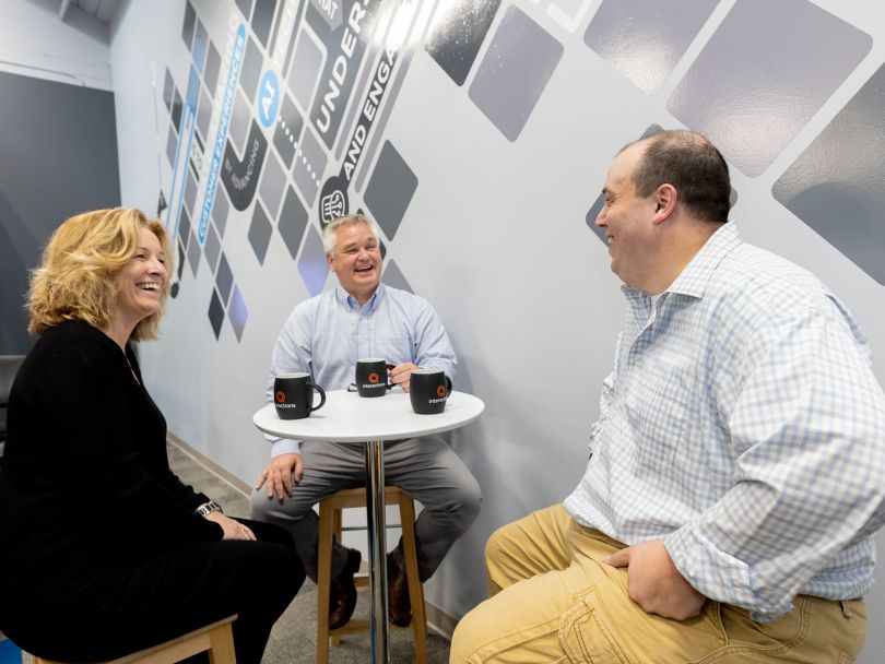 Interactions team members discussing strategy over coffee