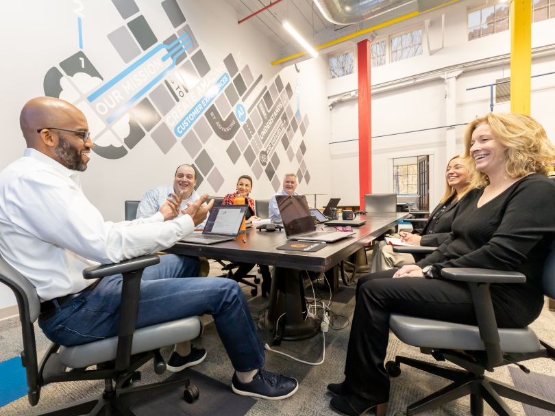 Interactions team members talking at conference table
