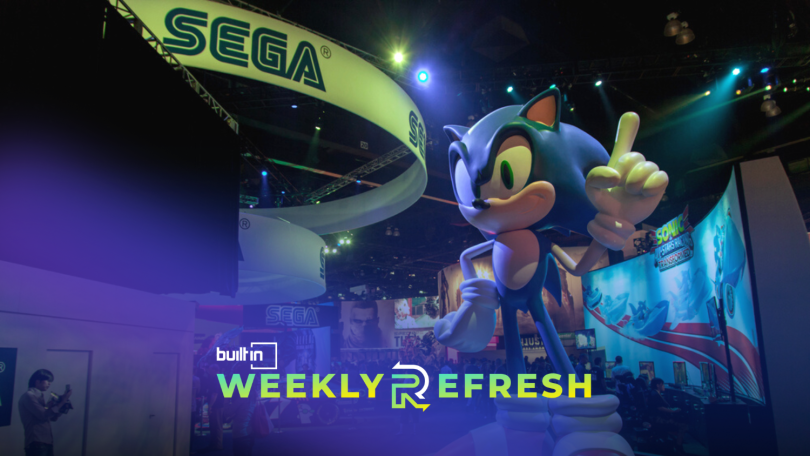 A Sonic the hedgehog at a convention underneath a Sega banner.