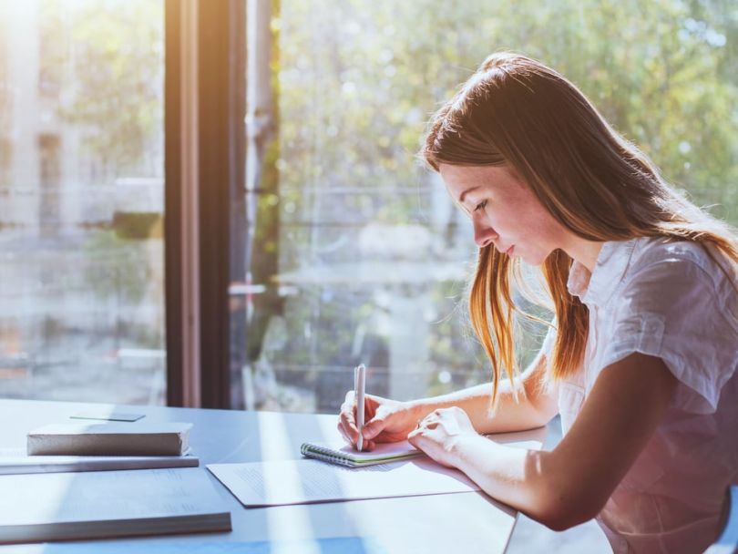 Woman sitting in the sunlight studying