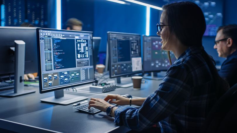 IT Programer Working on Desktop Computer in Data Center System Control Room