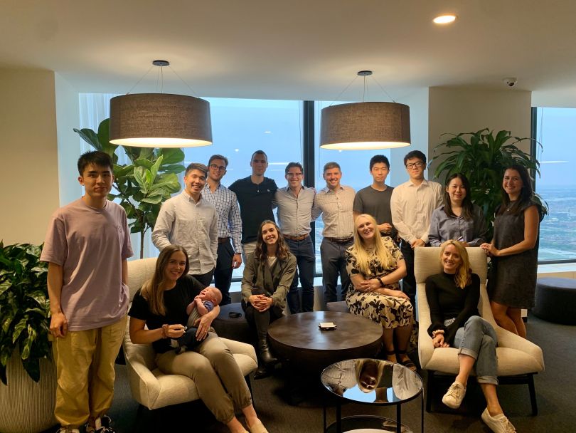 Magma Capital Funds employees sitting around a table and smiling.