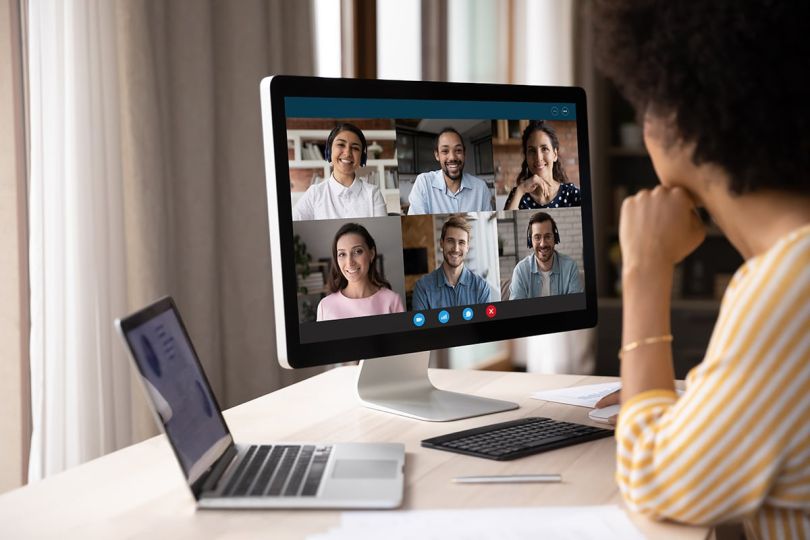 businesswoman looking at computer monitor, holding video conference online call with colleagues