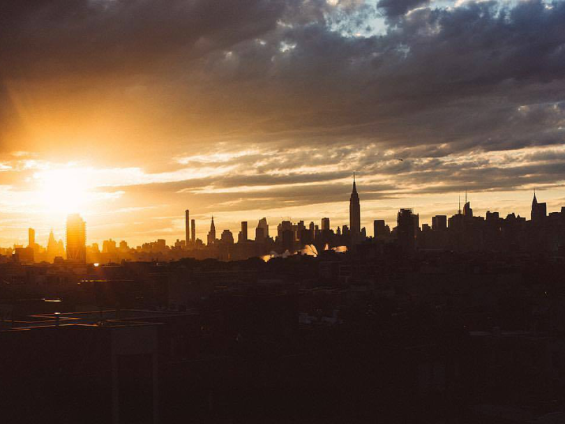 An orange and yellow sunset over the Manhattan skyline