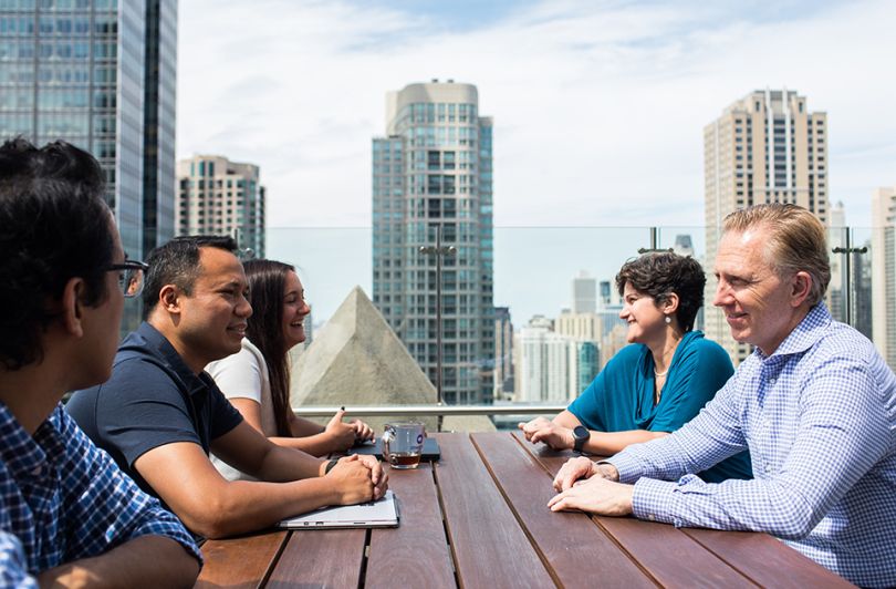 OneSpan team seated outside on rooftop