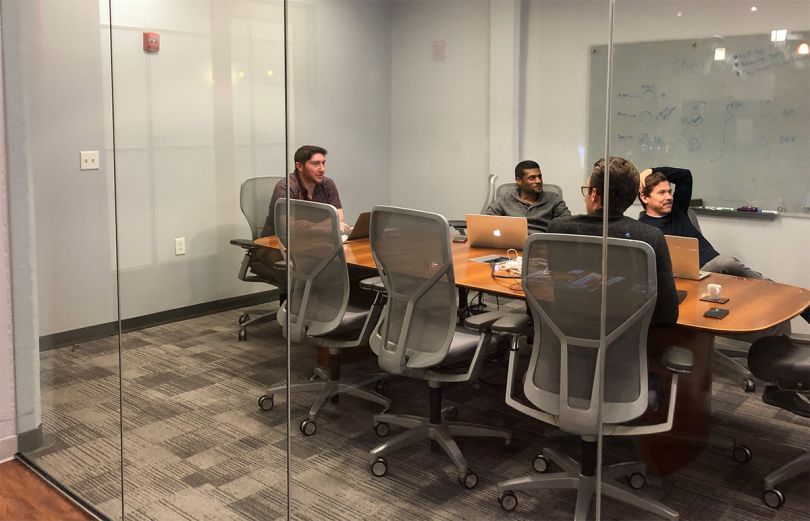 OneView Commerce team members having a meeting in a conference room in the office