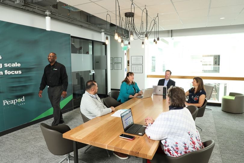 Peapod Digital Labs team members sitting at a conference table in the office