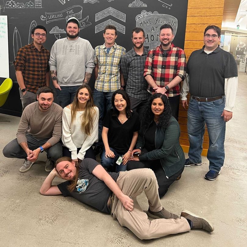 PeerStreet team members standing in front of a chalkboard with doodles on it