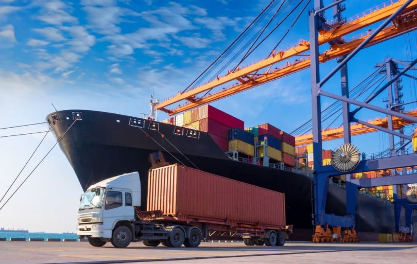 Freight truck situated in front on freight carrier boat at a dock