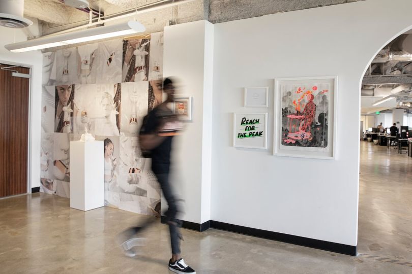 A blurry man walks through an office entry