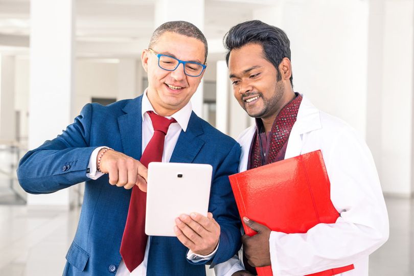 doctor with a businessman talking in hospital hallway