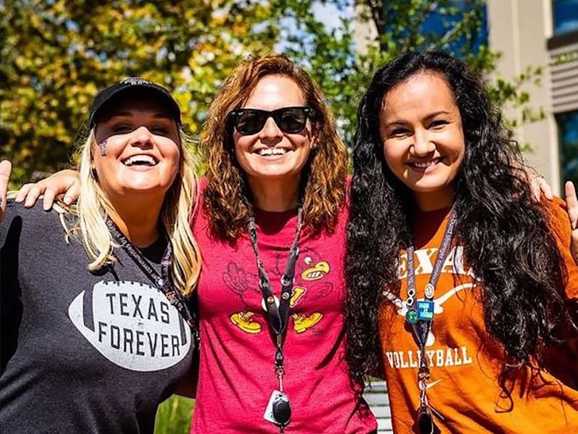 Q2 team members hanging out outside wearing college football t-shirts