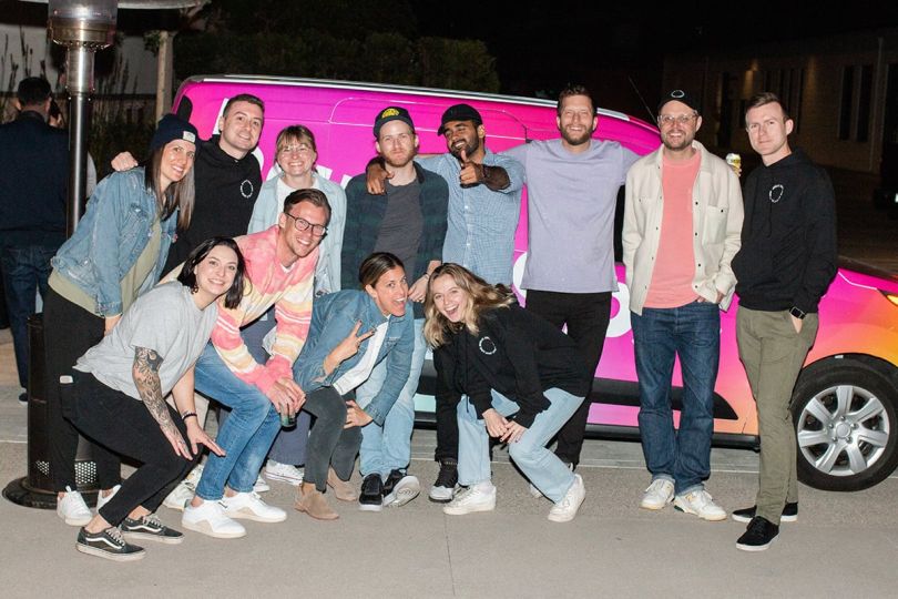 Repeat group photo in front of a hot pink van