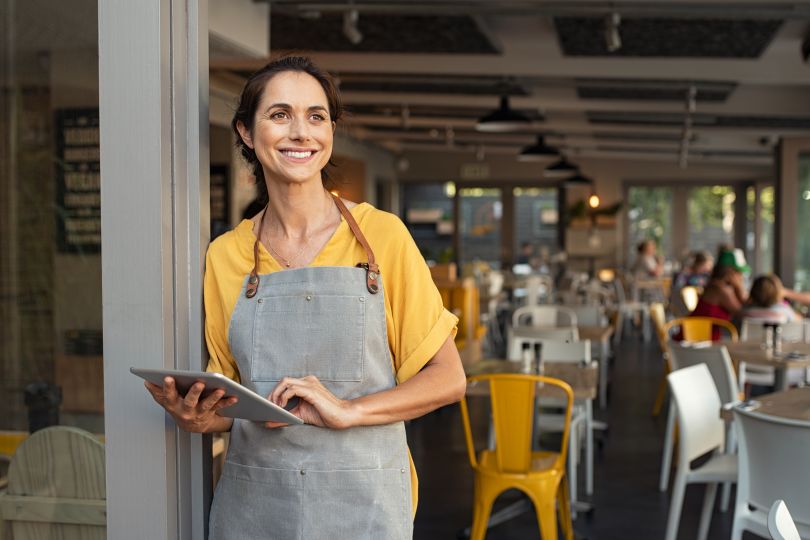  A restaurant owner stands in front of her business