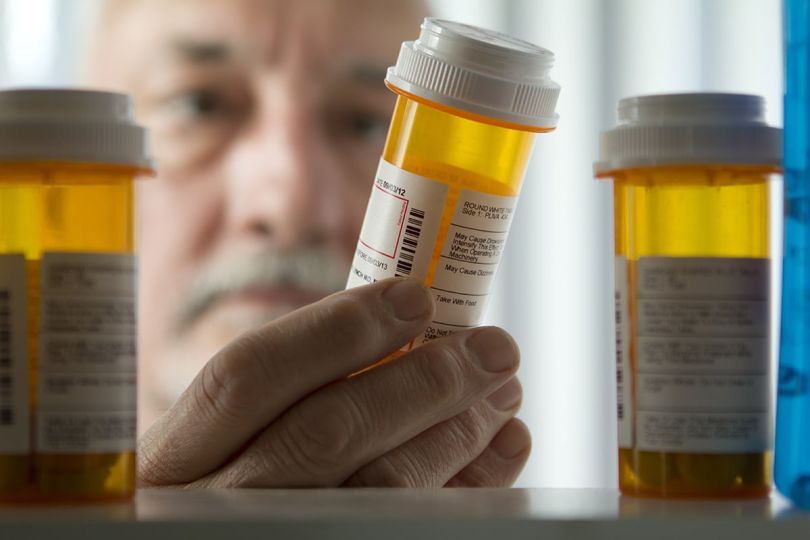 Man reading prescription bottle
