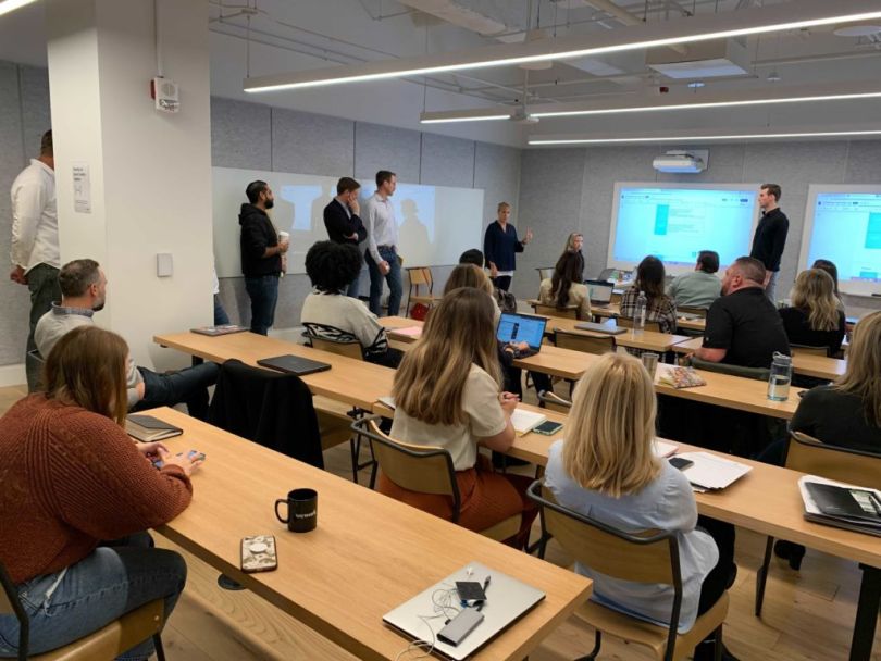  A large group sales meeting at Immersive Labs, set up in classroom-style seating.