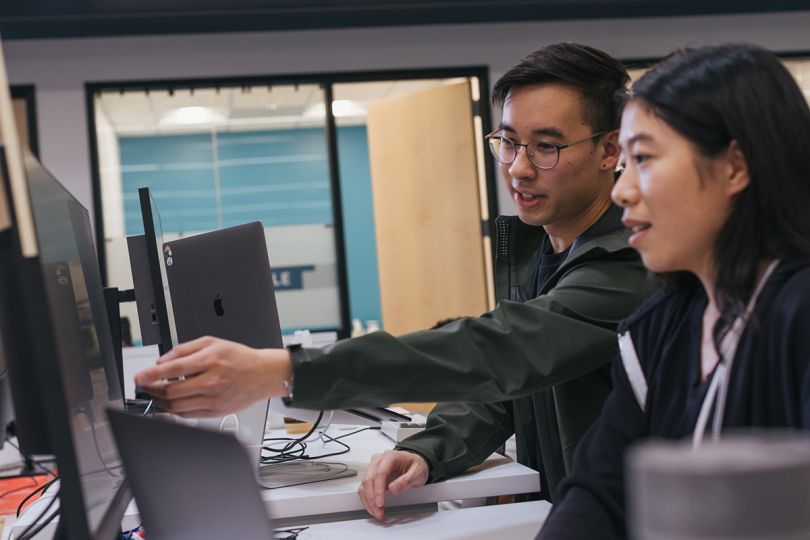 Two Samsara team members working on a project together looking at a computer monitor