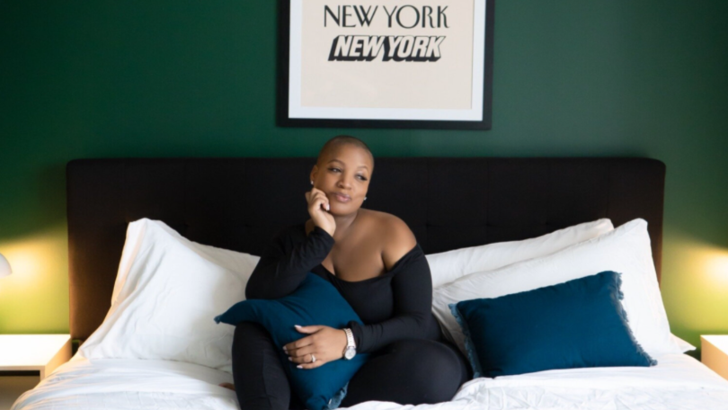  Jade Kearney, CEO of SheMatters sitting on bed smiling