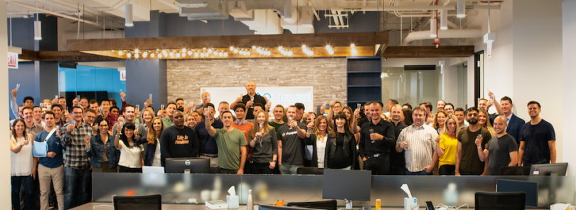 Showpad team in their office holding champagne glasses