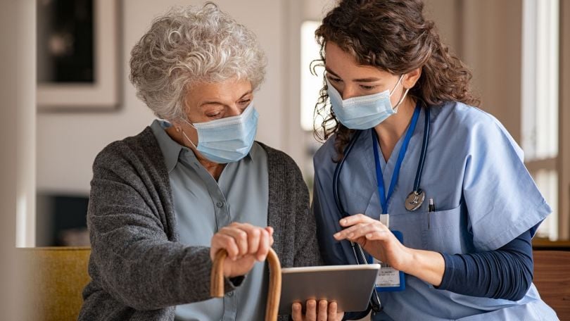 A healthcare professional assists a patient. 
