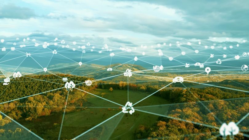 A forest superimposed with various elements of greentech.