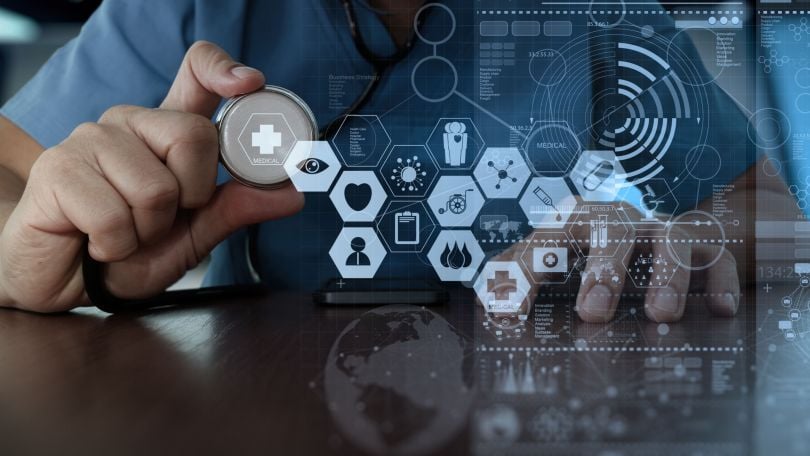 A medical professional interacts with health tech. 