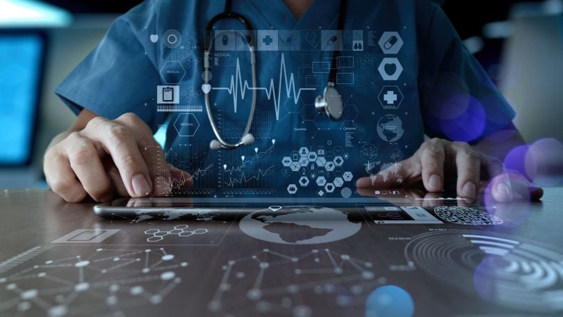 A healthcare professional uses technology. 