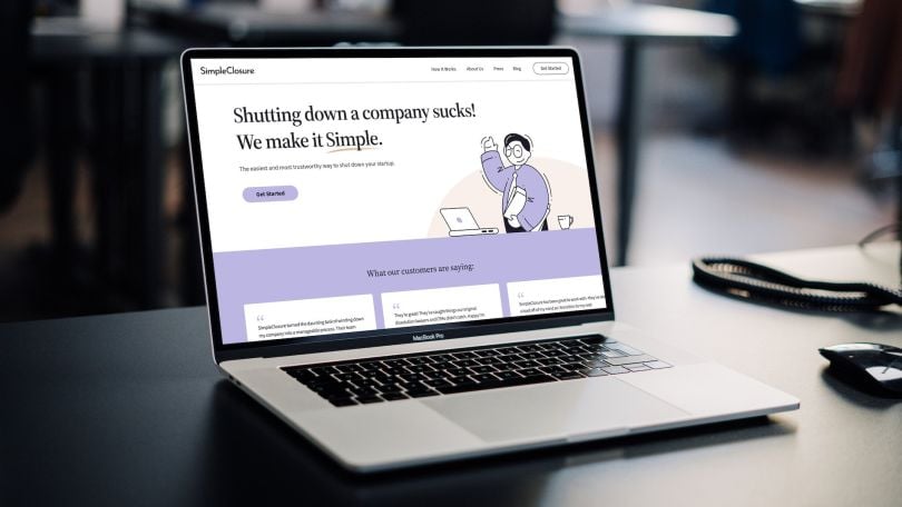 A laptop open on a desk with the SimpleClosure website pulled up.