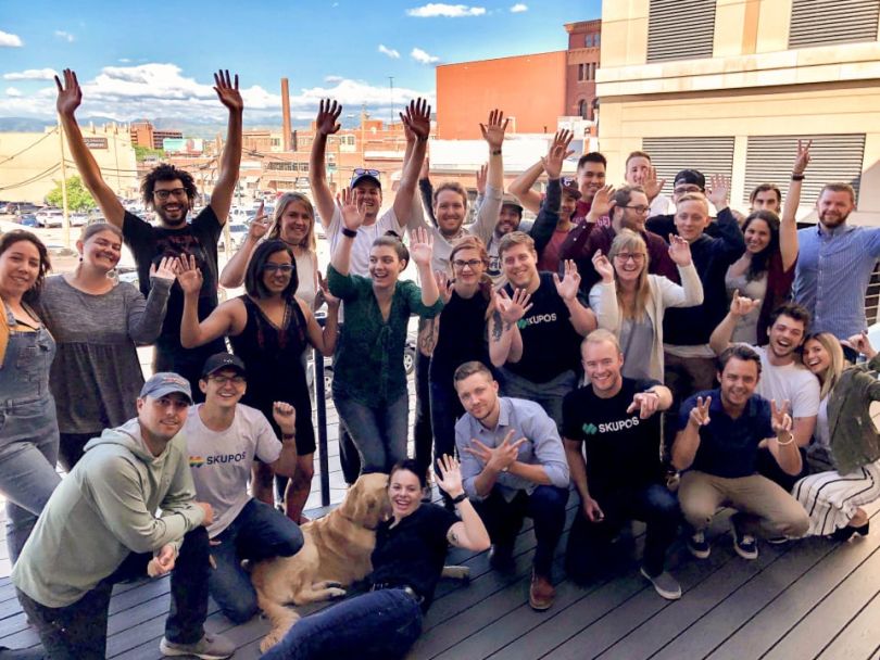 Skupos team in group photo on a balcony