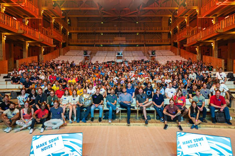 A large team seated inside of an auditorium. 