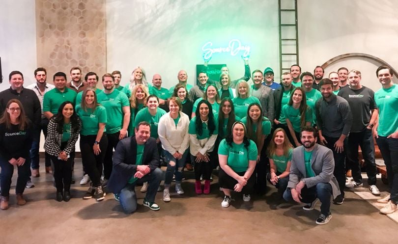 SourceDay team in the office wearing green SourceDay t-shirts