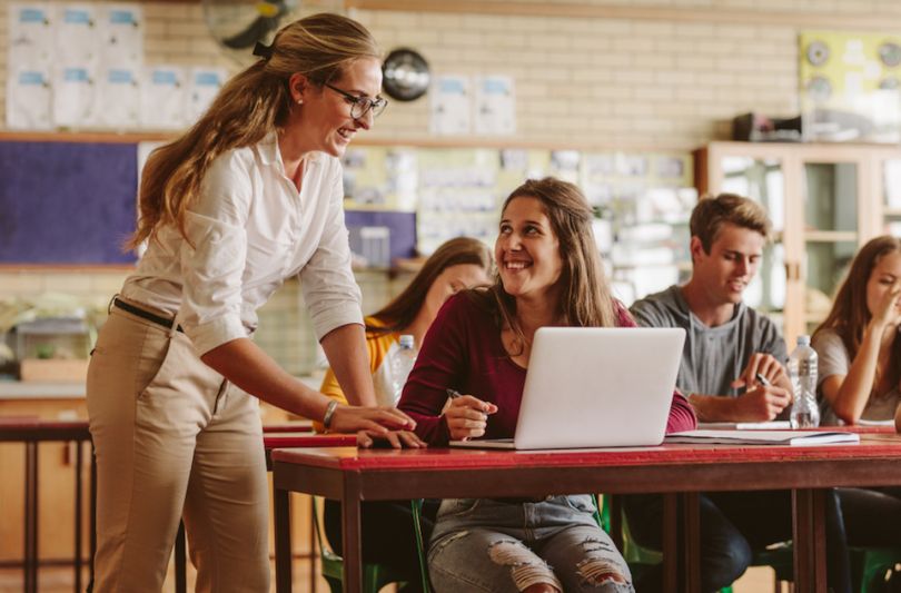 Teacher assisting smiling student