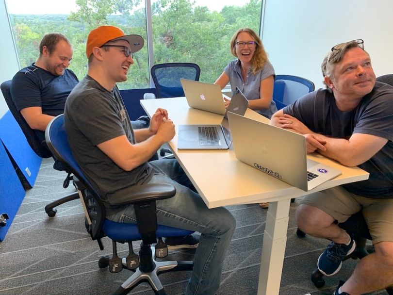 TrustRadius team members chatting and laughing in conference room