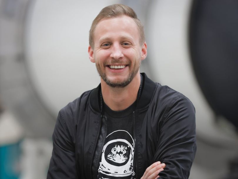 Will Leahy in a Built In T-shirt standing in front of a rocketshit
