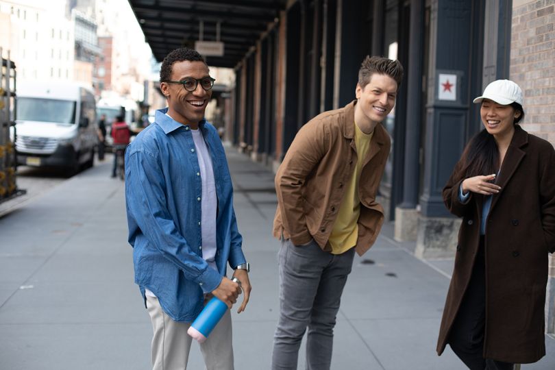 Wix team members outside on the sidewalk of a city street smiling and laughing