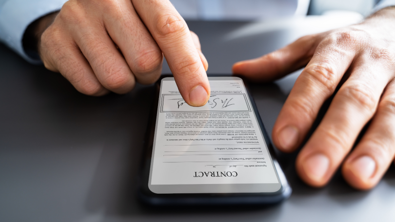 Finger touching phone screen too sign contract online