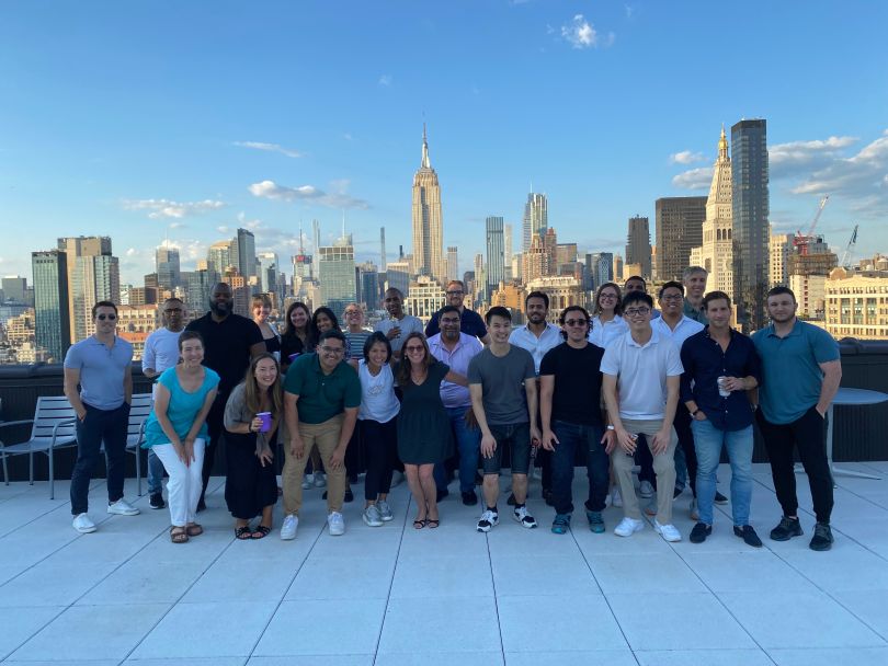 Photo of the Axoni team together on a rooftop with the skyline in the background. 