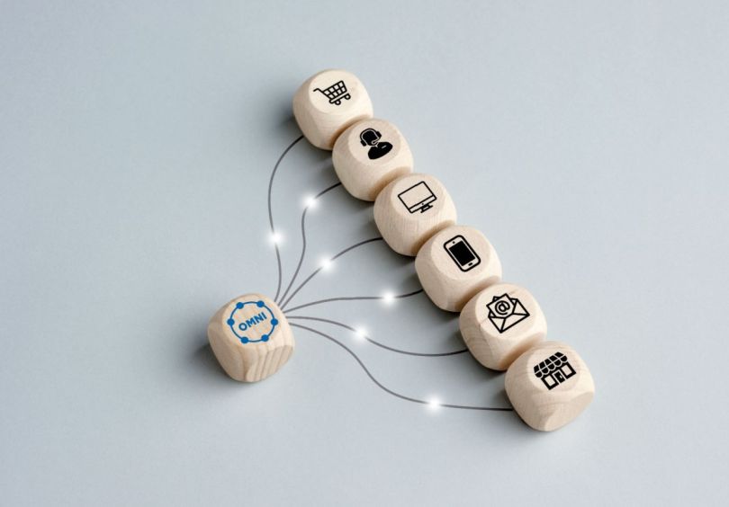 A single wooden block with ‘omni’ written on it connects to several other blocks with icons relating to technology and the consumer experience.&nbsp;