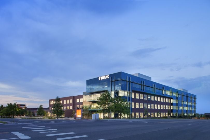 The exterior of FirstBank’s office building at dusk.