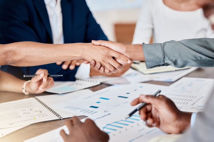 Two business people shaking hands are pictured.