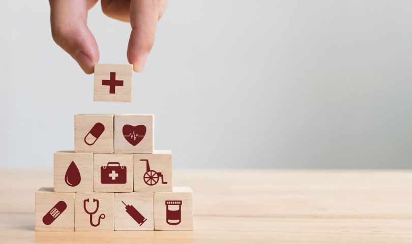 An image depicting wooden blocks with medical symbols on them is shown.