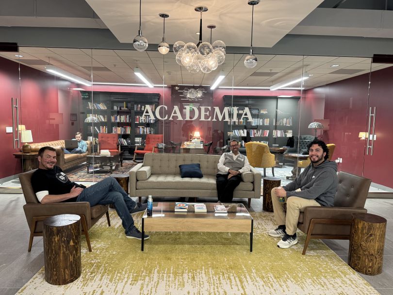 Academia.edu team members socializing in front of the office library.&nbsp;