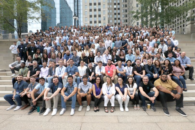 The entire Tegus team posing outdoors on a large granite staircase in Chicago