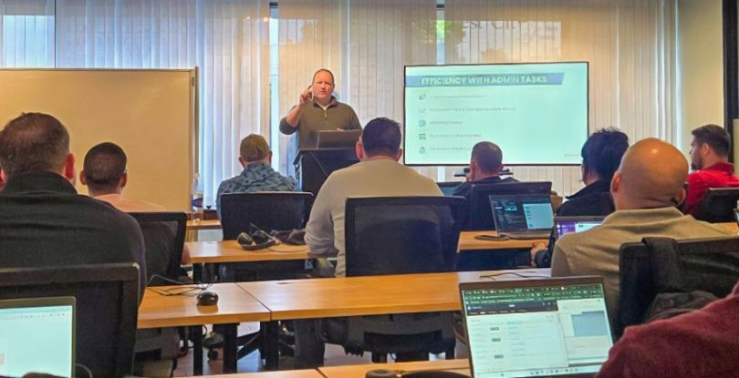 Andrew gives a presentation in front of a group of employees during a company onsite. 