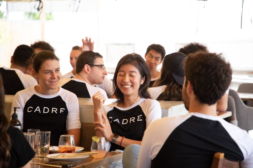 Cadre employees share a conversation while wearing Cadre t-shirts.